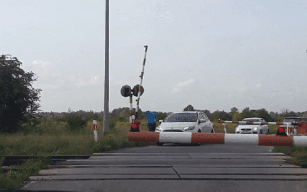 Podnieśli szlaban i wjechali na tory tuż przed pociągiem. Policja publikuje nagranie. „Igranie ze śmiercią” [WIDEO]