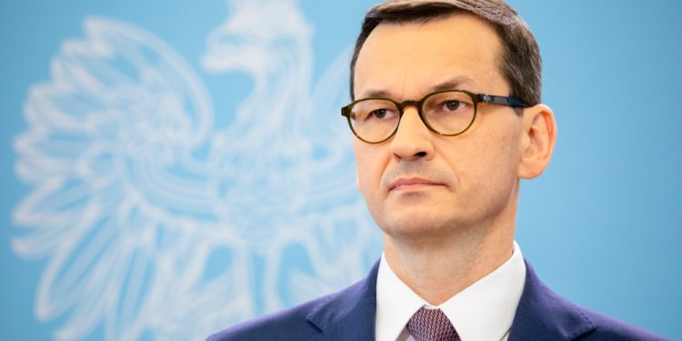 Premier Mateusz Morawiecki na tle orła białego