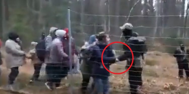 grupa ludzi przy ogrodzeniu