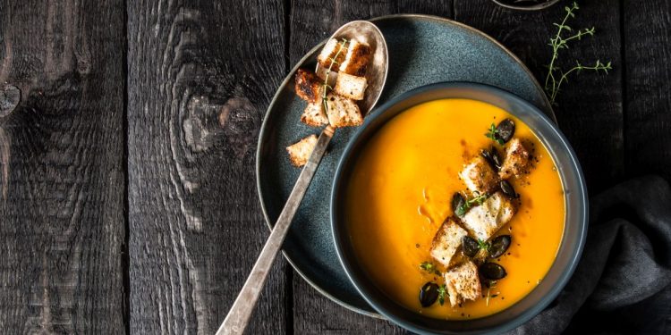 Zupa krem z dyni. Podana z grzankami, pestkami dyni i oliwą.